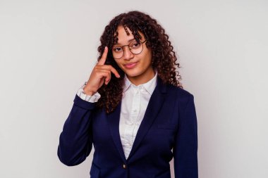 Beyaz arka planda izole edilmiş genç iş kadını şakağı işaret ediyor, düşünüyor ve bir göreve odaklanıyor..