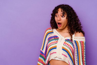 Mor arka planda izole edilmiş genç melez kadın gördüğü bir şey yüzünden şoka uğruyor..