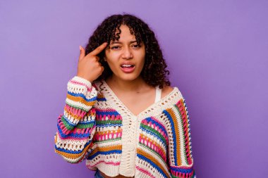 Mor arka planda izole edilmiş genç melez kadın işaret parmağıyla bir hayal kırıklığı gösteriyor..