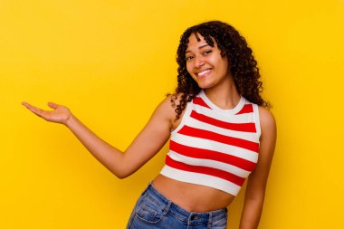 Sarı arka planda izole edilmiş genç melez kadın hoş bir yüz ifadesi sergiliyor..