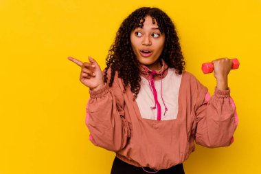 Sarı arka planda soyutlanmış genç, melez bir kadın.