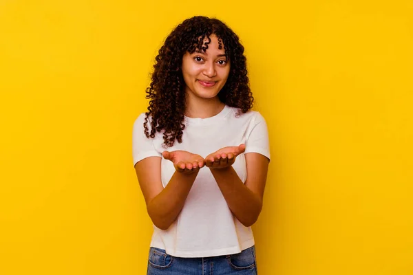 Young Mixed Race Woman Isolated Yellow Background Holding Something Palms — Stock Photo, Image
