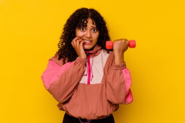 Sarı arka planda soyutlanmış genç, melez bir kadın.