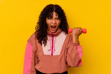 Sarı arka planda soyutlanmış genç, melez bir kadın.