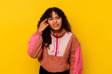 Pembe arka planda izole edilmiş genç melez kadın işaret parmağıyla bir hayal kırıklığı gösteriyor..