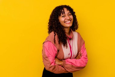 Genç melez kadın pembe arka planda izole edilmiş gülüyor ve eğleniyor..