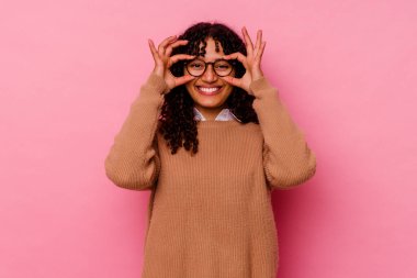 Pembe arka planda izole edilmiş genç melez kadın gözlerde sorun olmadığını gösteriyor.