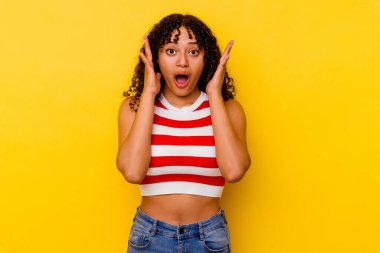 Sarı arka planda yaşayan genç melez kadın şaşırdı ve şok oldu..