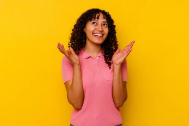 Sarı arka planda soyutlanmış genç bir ırk kadını elini göğsüne bastırarak kahkahalar atıyor..