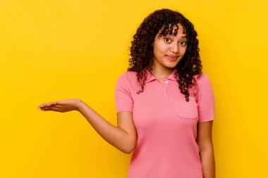 Sarı arka planda izole edilmiş genç bir ırk kadını bir avuç içinde fotokopi alanı ve belinde başka bir el tutarken görülüyor..