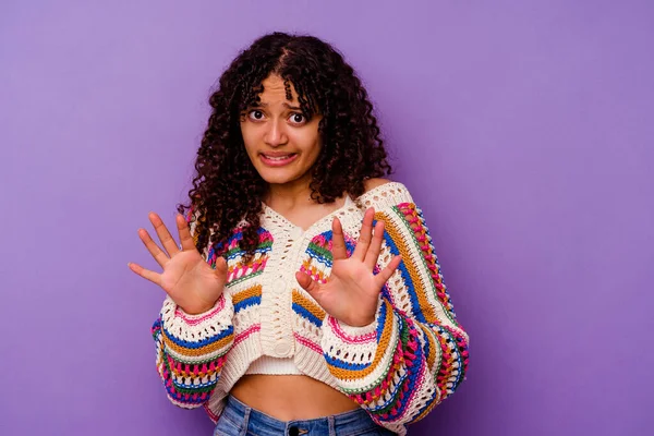 Mor arka planda izole edilmiş genç melez kadın tiksinti gösteren birini reddediyor..