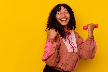 Sarı arka planda soyutlanmış genç, melez bir kadın.