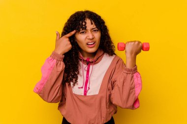 Sarı arka planda soyutlanmış genç, melez bir kadın.