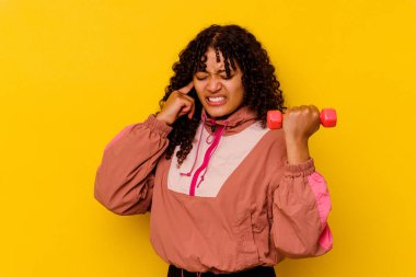 Sarı arka planda soyutlanmış genç, melez bir kadın.