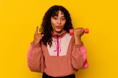 Sarı arka planda soyutlanmış genç, melez bir kadın.