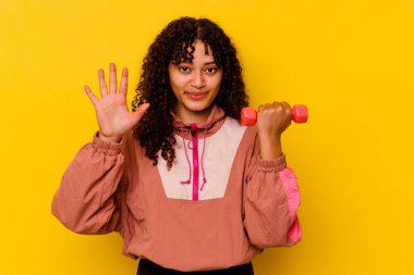 Sarı arka planda soyutlanmış genç, melez bir kadın.