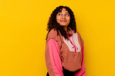 Pembe arka planda izole edilmiş genç melez kadın hedeflerine ve amaçlarına ulaşma hayali kuruyor.