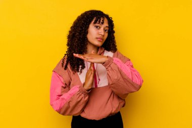 Pembe arka planda izole edilmiş genç melez kadın bir mola hareketi gösteriyor..