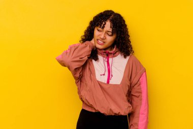 Genç melez kadın pembe arka planda izole edilmiş. Oturaklı yaşam tarzı nedeniyle boyun ağrısı çekiyor..