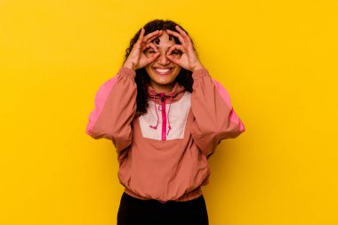 Pembe arka planda izole edilmiş genç melez kadın gözlerde sorun olmadığını gösteriyor.