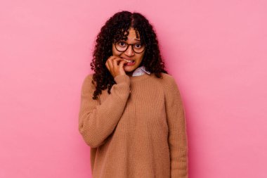 Pembe arka planda izole edilmiş, tırnak yiyen, gergin ve endişeli genç bir ırk..