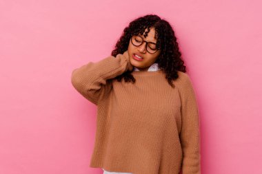 Genç melez kadın pembe arka planda izole edilmiş. Oturaklı yaşam tarzı nedeniyle boyun ağrısı çekiyor..