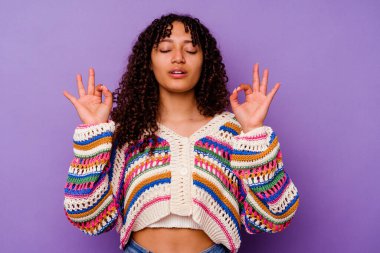 Mor arka planda soyutlanmış genç melez kadın yoğun bir günün ardından rahatlıyor, yoga yapıyor..