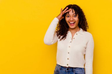 Sarı arka planda soyutlanmış genç melez kadın yüksek sesle bağırıyor, gözleri açık ve elleri gergin tutuyor..