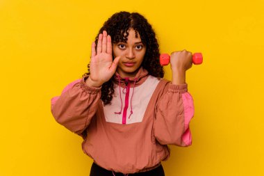 Sarı arka planda soyutlanmış genç, melez bir kadın.