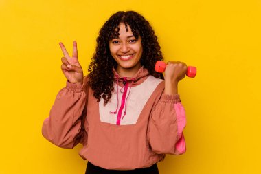 Sarı arka planda soyutlanmış genç, melez bir kadın.