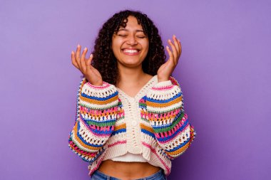 Mor arka planda izole edilmiş genç bir ırk kadını neşeli bir şekilde gülüyor. Mutluluk kavramı.
