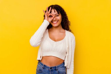 Sarı arka planda izole edilmiş genç melez bir kadın heyecanlı, tamam mı?.