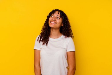 Sarı arka planda izole edilmiş genç bir ırk kadını rahat ve mutlu bir gülüş, boynunda dişlerini gösteren bir gerdanlık..