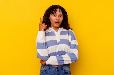 Sarı arka planda soyutlanmış genç melez bir kadının harika bir fikri var, yaratıcılık kavramı..