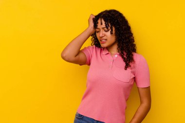 Sarı arka planda izole edilmiş genç melez kadın zaferi, tutkuyu ve coşkuyu kutluyor, mutlu bir ifade..