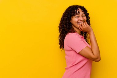 Sarı arka planda izole edilmiş genç bir ırk kadını rahat bir şekilde fotokopi odasına bakan bir şeyi düşünüyor..