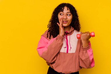 Sarı arka planda soyutlanmış genç, melez bir kadın.