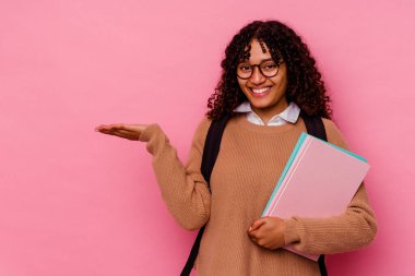 Pembe arka planda izole edilmiş genç öğrenci ırk kadını bir avuç içinde fotokopi alanı ve belinde bir el daha gösteriyor..