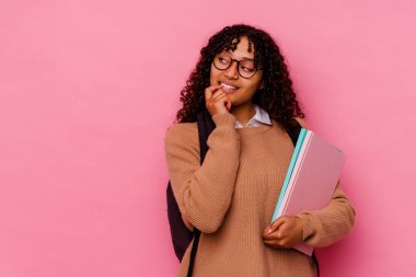 Pembe arka planda soyutlanmış, genç, melez bir kadın. Bir şeyin fotokopi alanına baktığını düşünüyor..