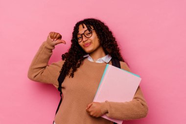 Genç öğrenci melez kadın pembe arka planda izole edilmiş gururlu ve kendinden emin hissediyor, örnek olarak..