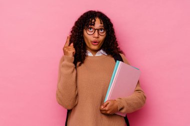 Pembe arka planda izole edilmiş, ağzı açık genç bir kız öğrenci..