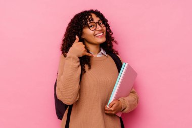 Pembe arka planda izole edilmiş genç öğrenci ırk kadını parmaklarıyla bir cep telefonu hareketi gösteriyor..