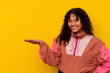 Pembe arka planda izole edilmiş genç bir ırk kadını bir avuç içinde fotokopi alanı ve belinde başka bir el tutarken görülüyor..