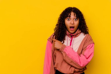 Pembe arka planda soyutlanmış genç melez bir kadın.