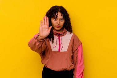 Pembe arka planda soyutlanmış genç melez bir kadın elini uzatmış, dur işareti göstererek seni engelliyor..