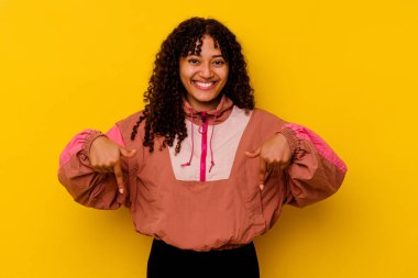 Pembe arka planda izole edilmiş genç melez kadın parmakları aşağıda, pozitif bir his..