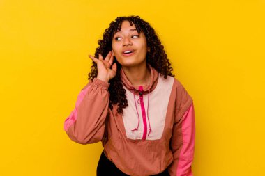 Pembe arka planda izole edilmiş genç melez kadın bir dedikoduyu dinlemeye çalışıyor..