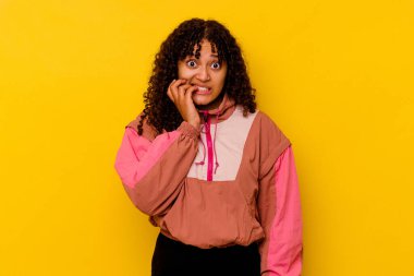 Pembe arka planda izole edilmiş, tırnak yiyen, gergin ve endişeli genç bir ırk..