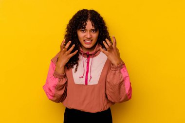 Pembe arka planda izole edilmiş genç melez kadın gergin ellerle çığlık atıyor..