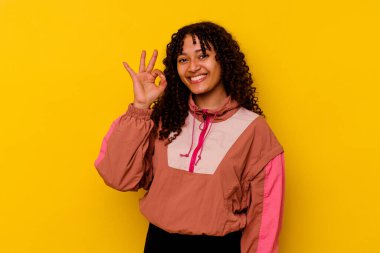 Genç melez kadın pembe arka planda izole edilmiş neşeli ve kendinden emin, iyi bir hareket gösteriyor..